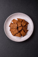 Crispy homemade brown bread chips with seeds and grains, salt, spices