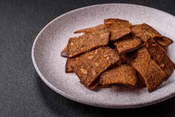 Crispy homemade brown bread chips with seeds and grains, salt, spices