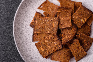 Crispy homemade brown bread chips with seeds and grains, salt, spices