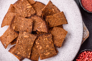 Crispy homemade brown bread chips with seeds and grains, salt, spices