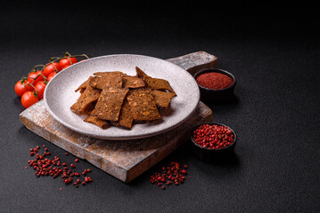 Crispy homemade brown bread chips with seeds and grains, salt, spices
