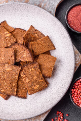 Crispy homemade brown bread chips with seeds and grains, salt, spices