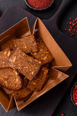 Crispy homemade brown bread chips with seeds and grains, salt, spices