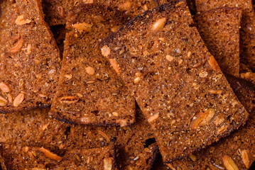 Crispy homemade brown bread chips with seeds and grains, salt, spices