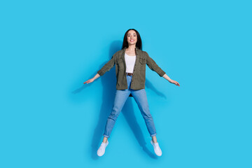 Cheerful Woman in Casual Clothing Against Blue Background Expressing Joy and Positivity