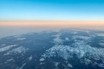 View of the earth and clouds from an airplane against the backdrop of the evening belt of Venus © Dushlik
