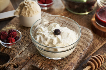 Greek yogurt in a bowl with whey protein and freeze dried berries - ingredients for healthy sweets