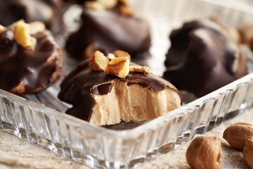 A bite of homemade healthy sweet dessert made with greek yogurt, nut butter and maple syrup coated in chocolate