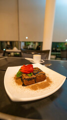 Brownie de chocolate con fresas y menta servido en un restaurante elegante
