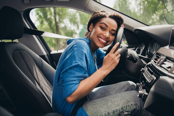 Confident young woman enjoying a day driving in the city, showing enthusiasm and happiness at the...