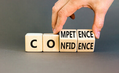 Competence and confidence symbol. Concept word Competence Confidence on wooden cubes. Businessman hand. Beautiful grey table grey background. Business competence confidence concept. Copy space.