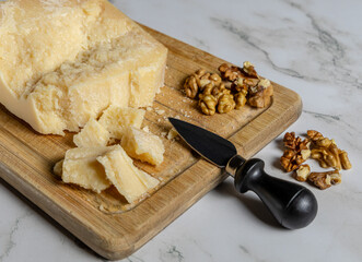 Tagliere in legno con formaggio di grana e noci