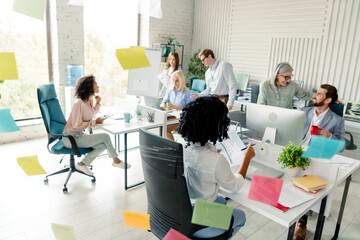 Fototapeta premium Diverse team collaborating in modern workplace with cheerful atmosphere and daylight