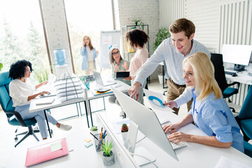 Professional team working together in a modern, collaborative office environment while sharing ideas and analyzing business data