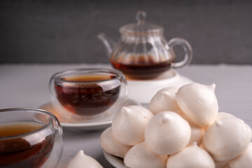 photo Indulge in the Elegant Combination of Light and Fluffy Meringue Cookies Paired with a Rich, Aromatic Black Tea for a Perfectly Balanced Tea Time Experience