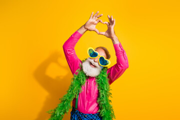 Photo of nice senior male dance boa show sign heart wear pink shirt plaid pants suspenders fancy outfit isolated on yellow color background