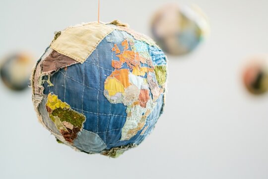 Minimalistic patchwork planet Earth made of recycled fabrics, symbolizing sustainability and upcycling concepts