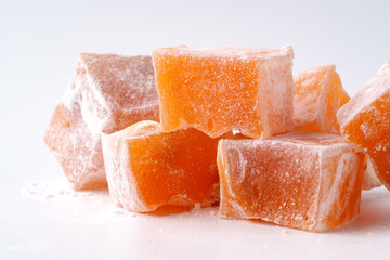 Turkish delight cubes in orange flavor arranged on a plain background for dessert enthusiasts