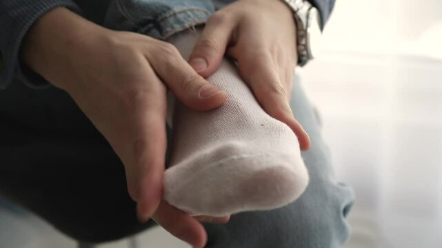 A man massages his leg.
A man in socks.
White socks on the feet of a young guy.
A man stretches his feet.
Foot, leg, massage, heel