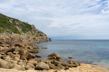 Rocky headland on the English South Coast with still sea and high clouds. Flat economic growth.