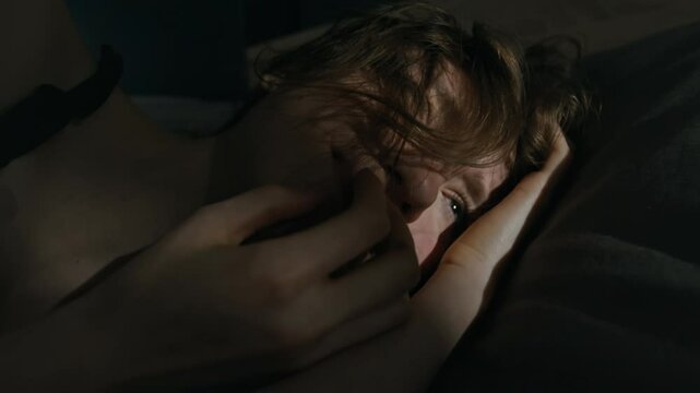 Close-up shot of anxious gen Z girl nervously touching hair and face suffering from paranoia and feeling someone watching her and trying to harm