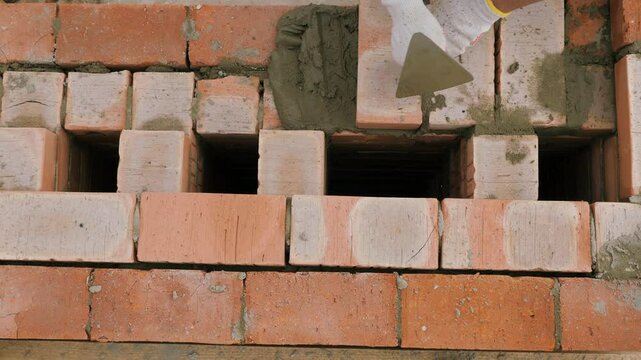 Laying out a brick chimney chimney of a private wooden house.