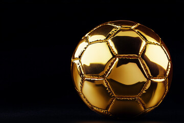 Naklejka premium Gold soccer ball isolated on a black background