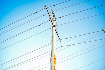 Top angle view of a power line standing against a clear blue sky background. Outdoor photography.