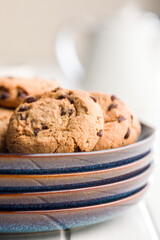 Chocolate chip cookies on plate on white table.