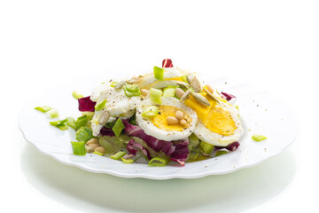Light salad with egg in a plate, isolated on white background