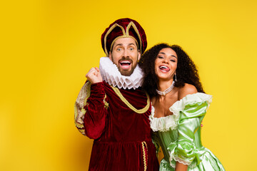 Playful couple in cosplay costumes against bright background