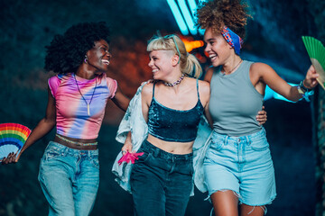 Friends walking and laughing together at music festival