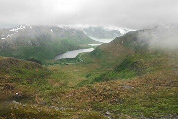 A misty mountain landscape, lake, and road in Norway. 