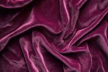 Fototapeta premium Plush burgundy velvet fabric with intricate soft folds and highlights