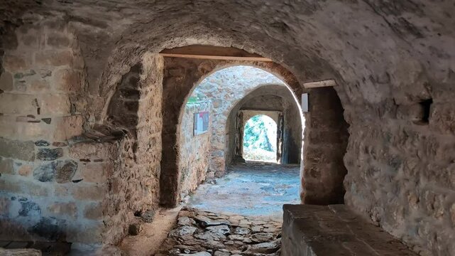 Walking through the charming streets of Monemvasia, Greece, under clear skies and bright sunlight