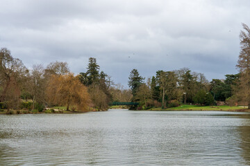 Serene lake surrounded by trees and gentle clouds on a cloudy afternoon