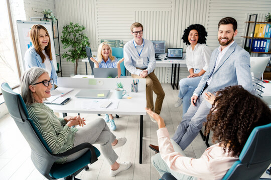 Diverse professional team meeting in a modern office discussing ideas and enjoying a productive and collaborative session