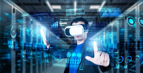 Businessman with headset standing at data center while analyzing financial data. Manager pointing marketing statistic hologram and using augmented reality goggles while making a decision. Ingenuity.