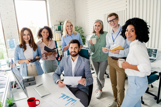 Professional team collaborating in modern office environment with diverse people wearing formalwear