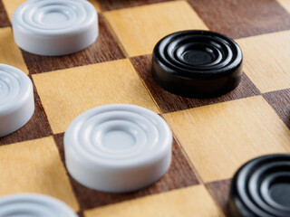 Checkers game setup on a checkered board. Strategy, game pieces, black and red, ready to play, board game.