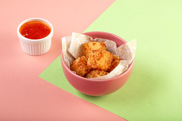 Tapioca fried squares with sweet chili sauce on colorful background