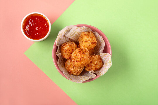 Tapioca fried squares with sweet chili sauce on colorful background