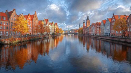 Obraz premium Scenic view of a riverside city with autumn foliage and historical buildings.