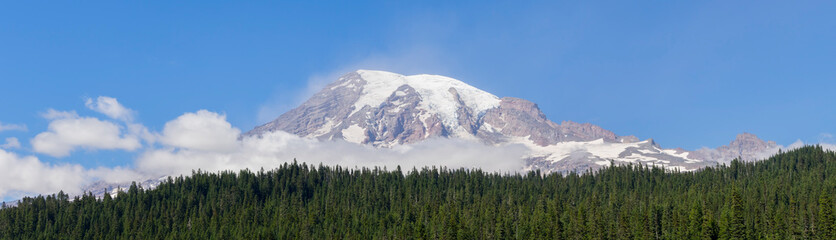 Fototapeta premium Washington State, Mount Rainier National Park. Snowcapped Mount Rainer and low clouds, view from Reflection Lakes area