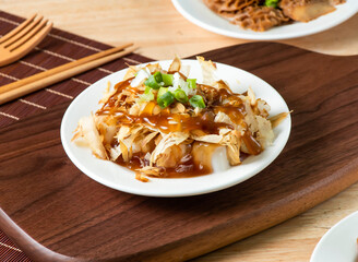 Tofu with Bonito Flakes and Sauce served in plate with fork and chopsticks isolated on wooden board side view of taiwan food