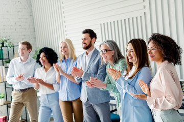 Diverse team of colleagues clapping in an office, showcasing teamwork, collaboration, and...