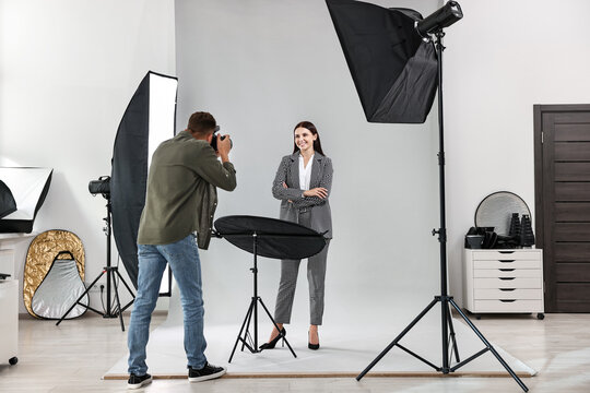 Photographer working with model in professional photo studio - Powered by Adobe