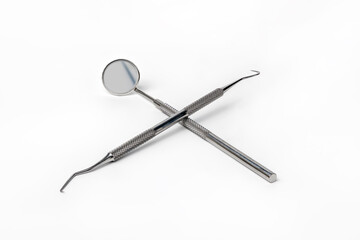 Dental Mirror and Pig Tail Explorer Probe Pick Oral Health Tools Crossed Isolated on white background