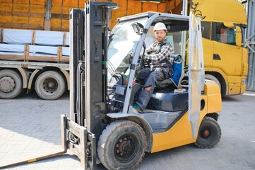 Naklejka premium Man worker at forklift driver happy working in industry factory logistic ship