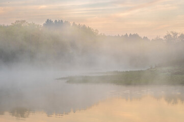 Fototapeta premium USA, West Virginia, Blackwater Falls State Park. Sunrise on lake and forest in fog.